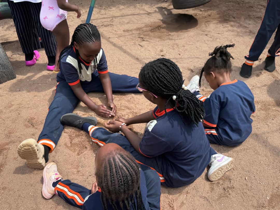Learners gathered during an outdoor play activity.