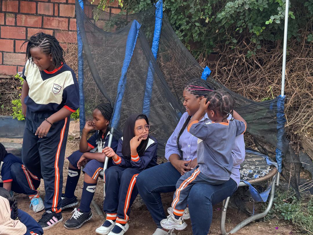Learners taking a break near the trampoline.