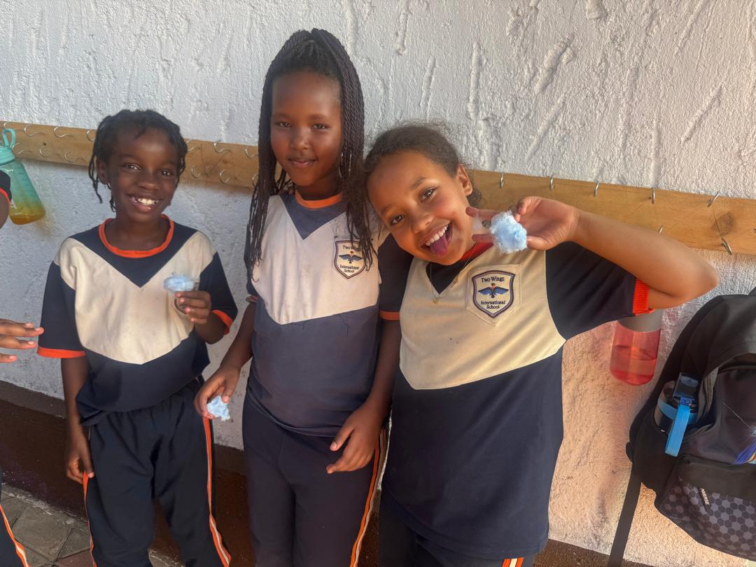 Three TWIS learners smiling together.